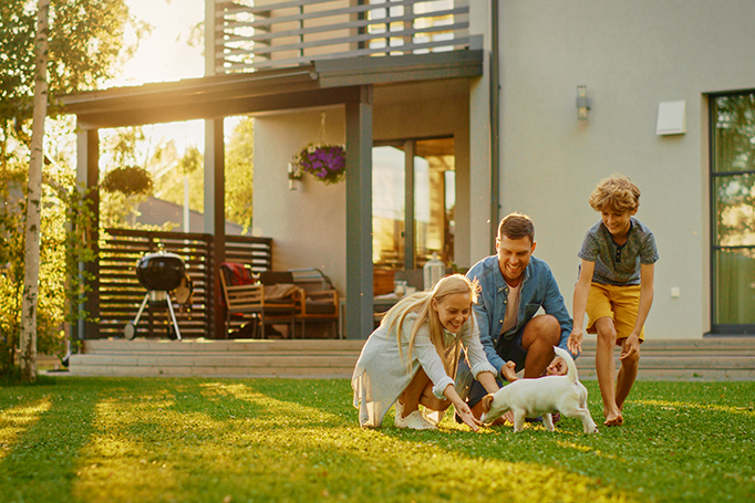 Family playing with dog in their yard