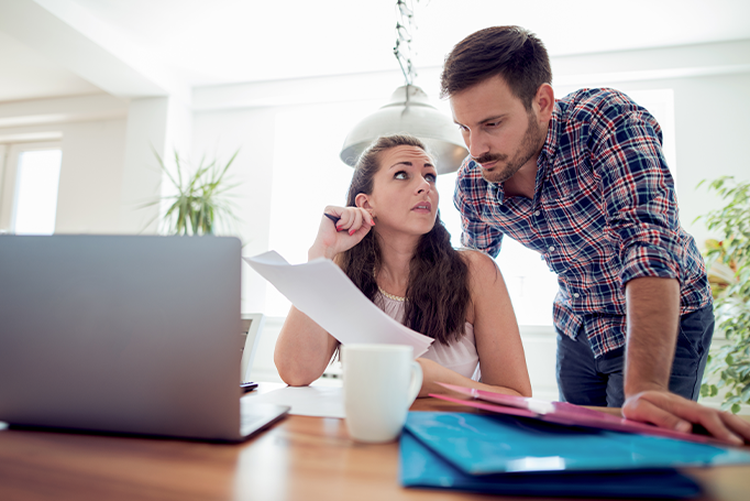 Concerned woman holding a document looking at man